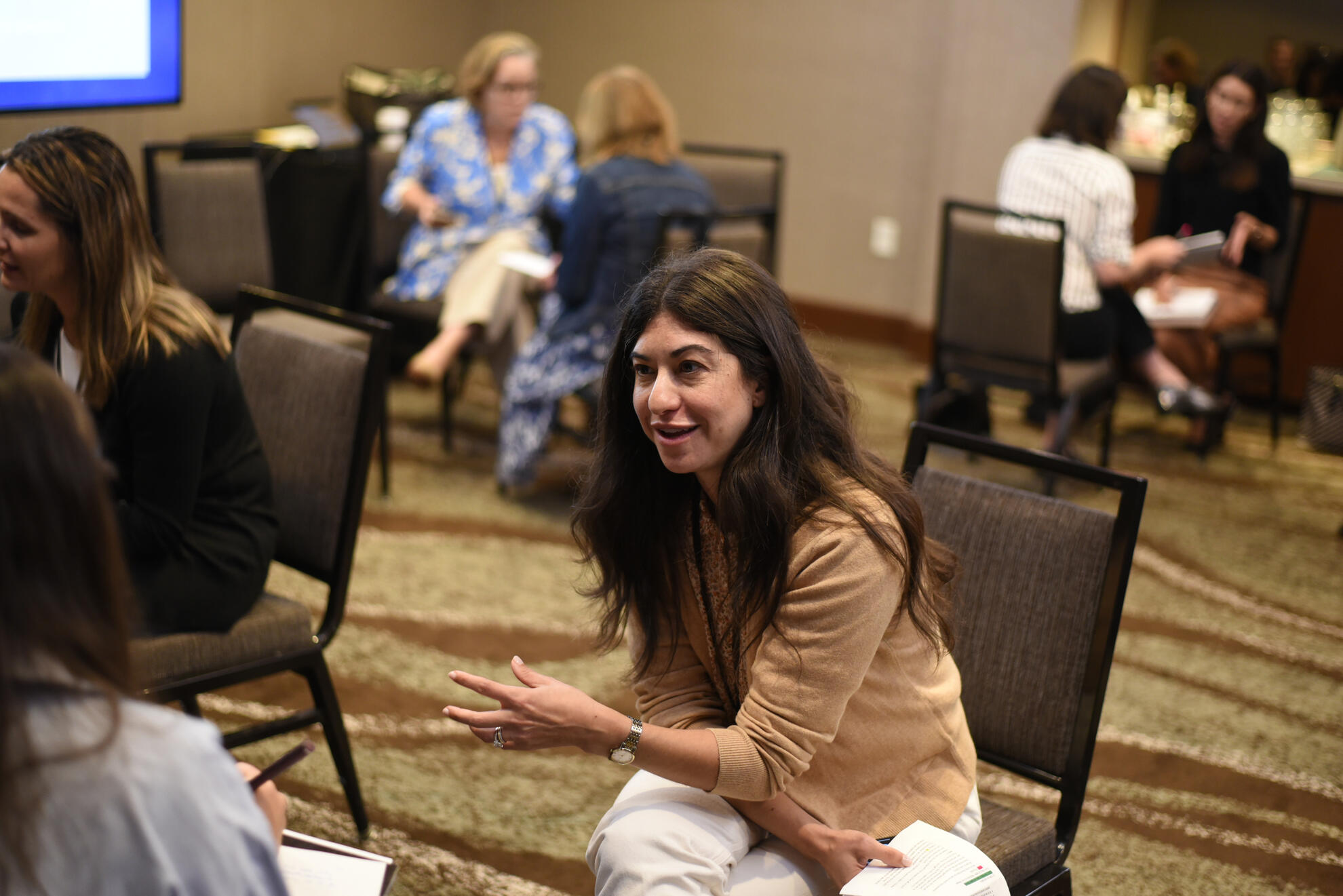 Professional woman speaking during breakout session at association conference — captured mid-conversation with candid energy and warmth.